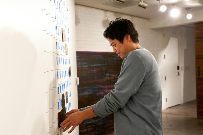 Visiting from Los Angeles, Evan Chiu, 40, hangs his painted square in its appropriate spot on pegs used to create an  iconic image of art displayed in P3Studio during James Adkins' in-house residency at The Cosmopolitan of Las Vegas Friday, January 11, 2013.